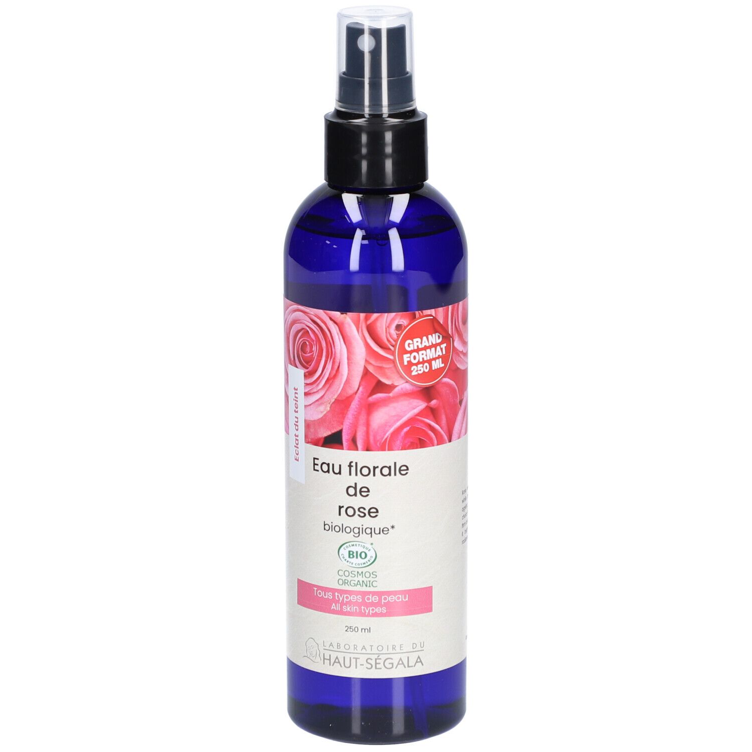 Blauwe fles met verstuiver. Etiket met rozenmotief en tekst: Eau florale de rose biologique. Bio-certificering. Groot formaat.