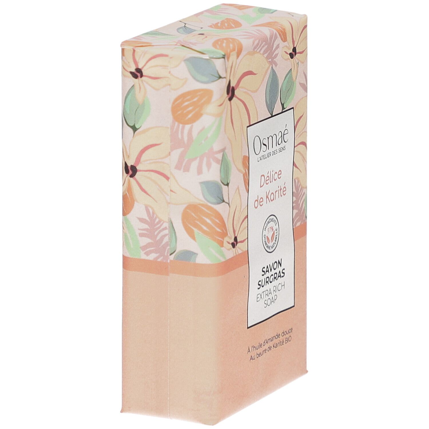 Schuin geplaatste zeep in verpakking. Opschrift: Osmaé, Délicé de Karité, Savon Surgras, Extra Rich Soap. Bloemenpatroon.