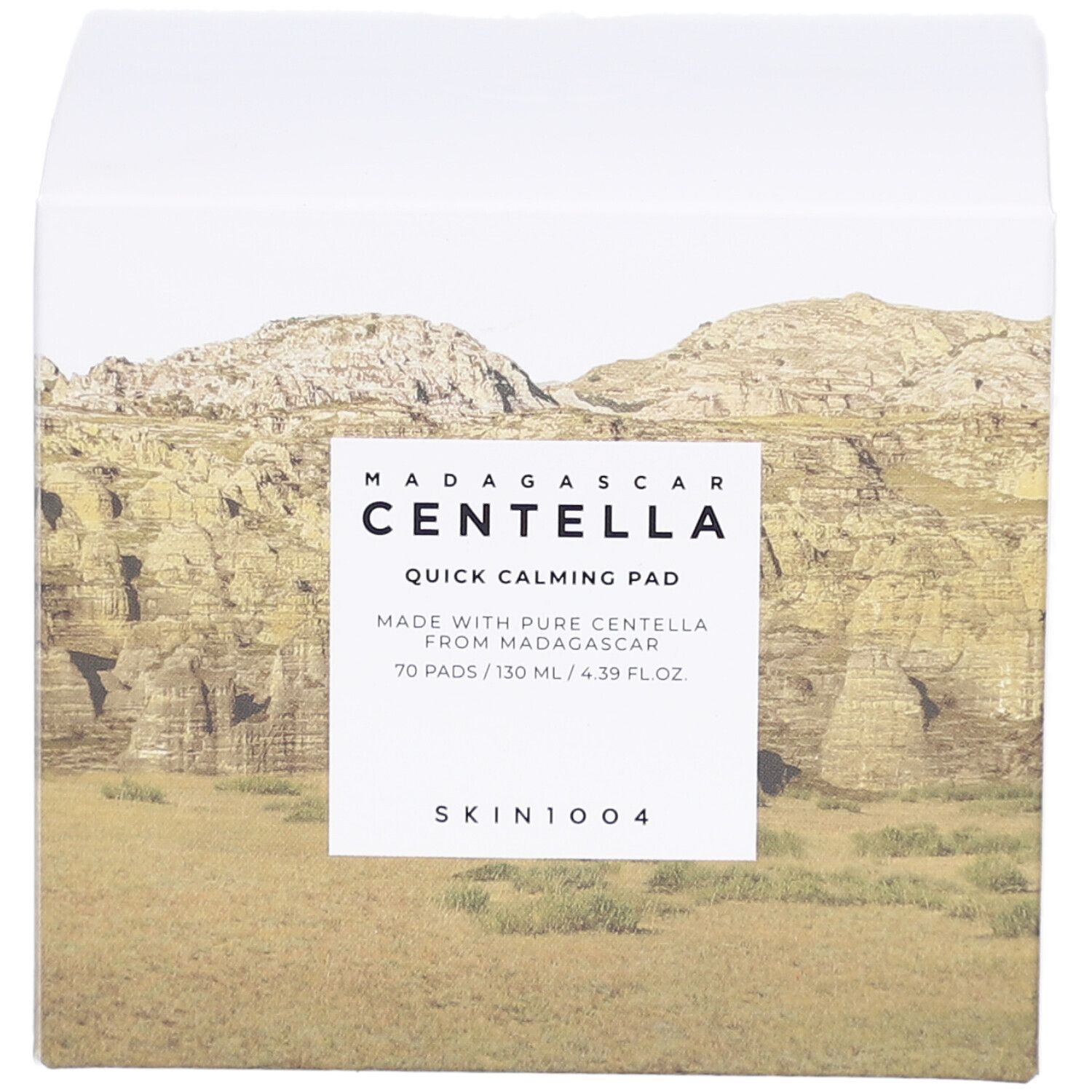 Witte verpakking met productinformatie. Opschrift: MADAGASCAR CENTELLA Quick Calming Pad. Merk: SKIN1004. Landschap.