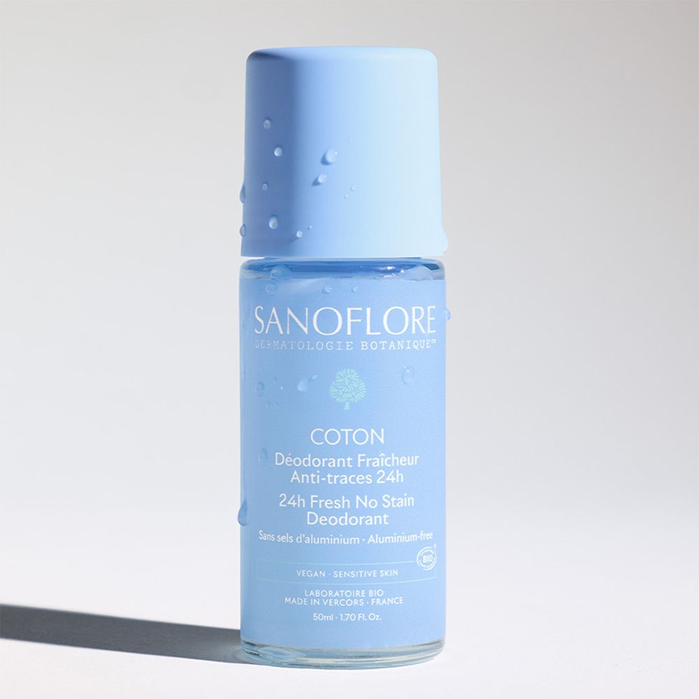 Déodorant roll-on bleu. Inscription : Sanoflore, Coton, 24H Fresh No Stain Deodorant. Sans sels d'aluminium. Gouttes sur le bouchon.