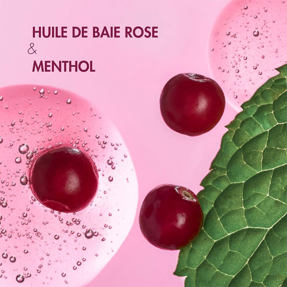 Gros plan sur des baies rouges, des feuilles et du liquide rose. Texte: Huile de baie rose & menthol.