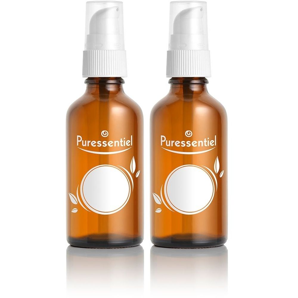 Twee bruine glazen flacons met pompkop. Opschrift "Puressentiel" en wit etiket. Witte bladerdecoratie.