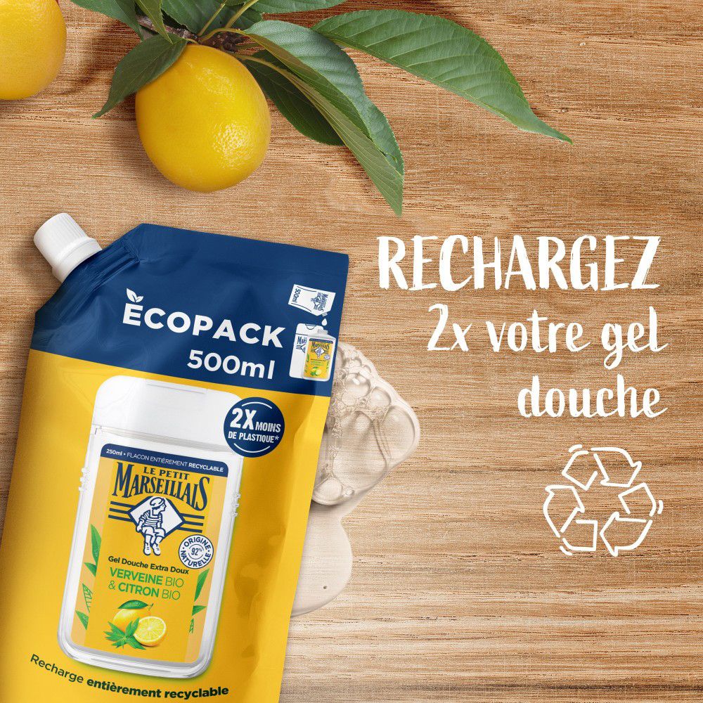 Recharge et symbole de recyclage. Texte: 2x votre gel douche. Produit sur surface en bois.