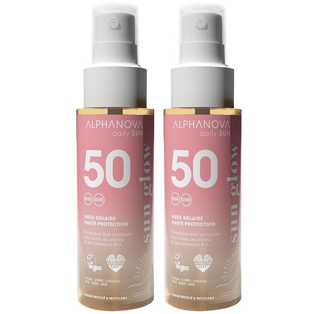 Twee sprayflacons zonnebrandolie. Roze etiket met witte tekst: ALPHANOVA, 50 SPF, Sun Glow. Vegan logo.