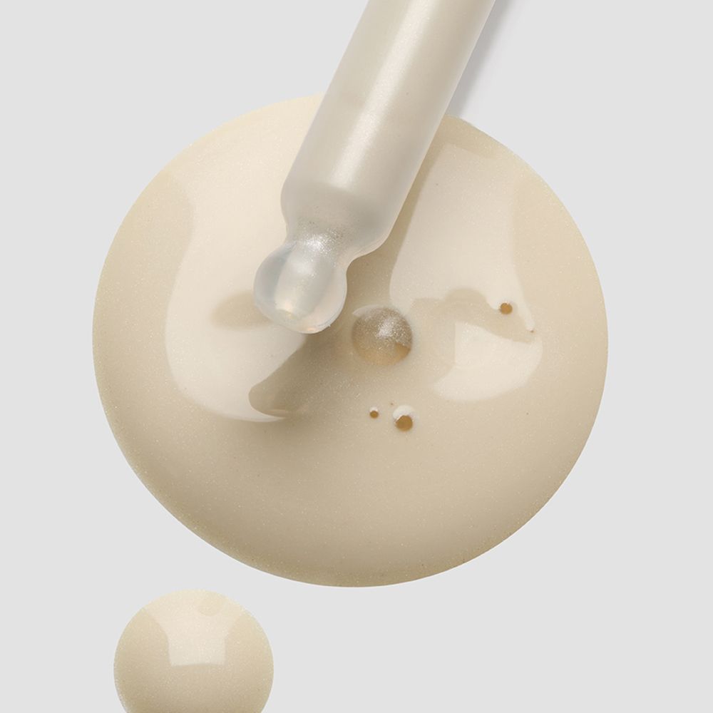 Pipet met witte vloeistof. Druppels op oppervlak.