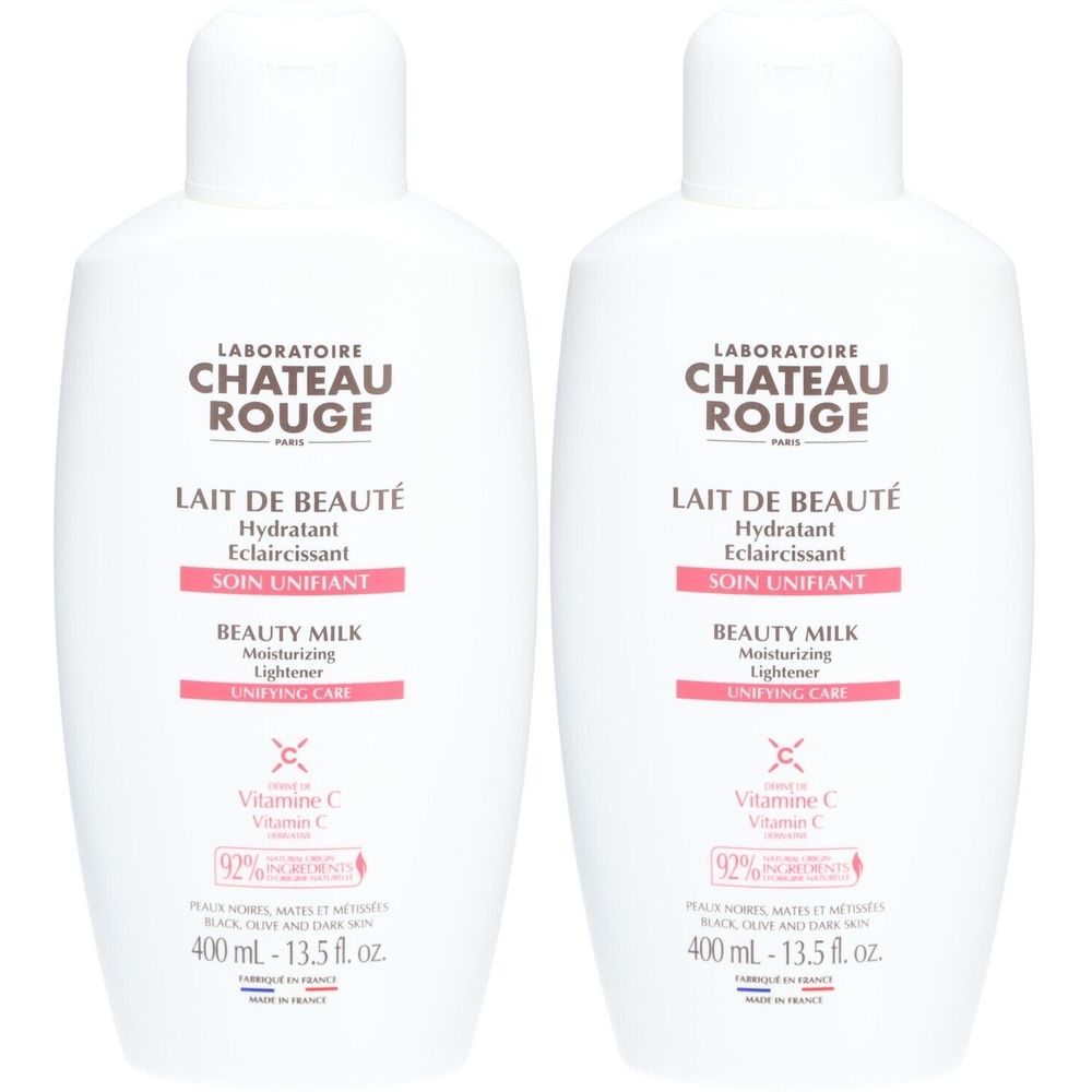 Twee witte flessen met etiketten. Opschrift: Laboratoire Château Rouge, Lait de Beauté, Soin Unifiant, Beauty Milk.