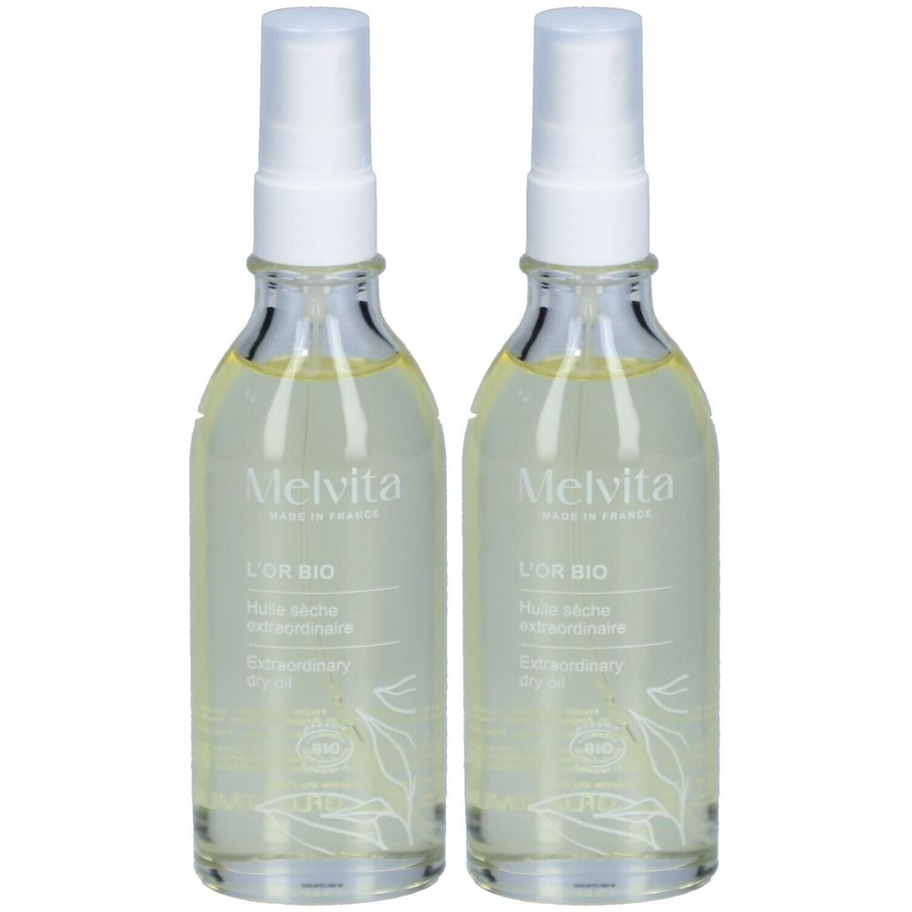 Twee glazen flessen met verstuiver. Opschrift: Melvita, L'Or Bio, Huile sèche extraordinaire, Extraordinary dry oil. Bio-keurmerk.