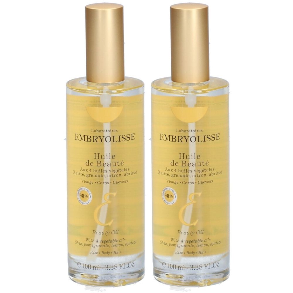 Deux flacons d'Huile de Beauté. Flacons en verre transparent avec bouchons dorés. Étiquette avec nom du produit et ingrédients.