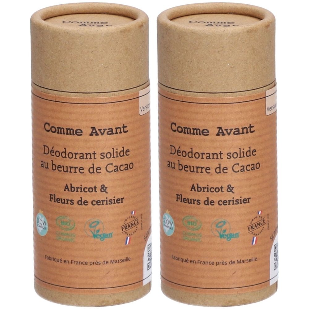 Twee cilindrische deodorants. Opschrift: Comme Avant, beurre de cacao, abrikoos & kersenbloesem. Bio- en vegan-logo's.
