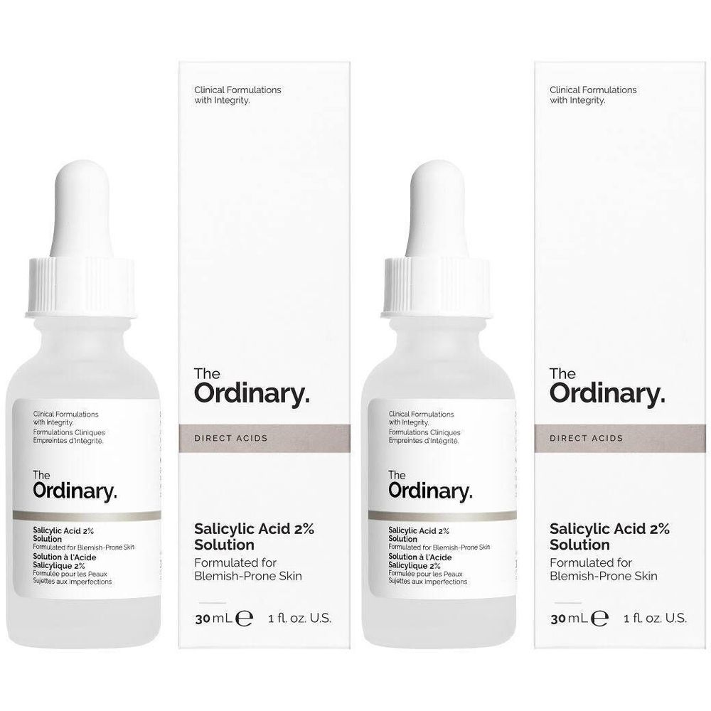 Drie flessen en verpakkingen van The Ordinary Salicylic Acid 2% Solution. Witte flessen met pipetten, witte verpakkingen.