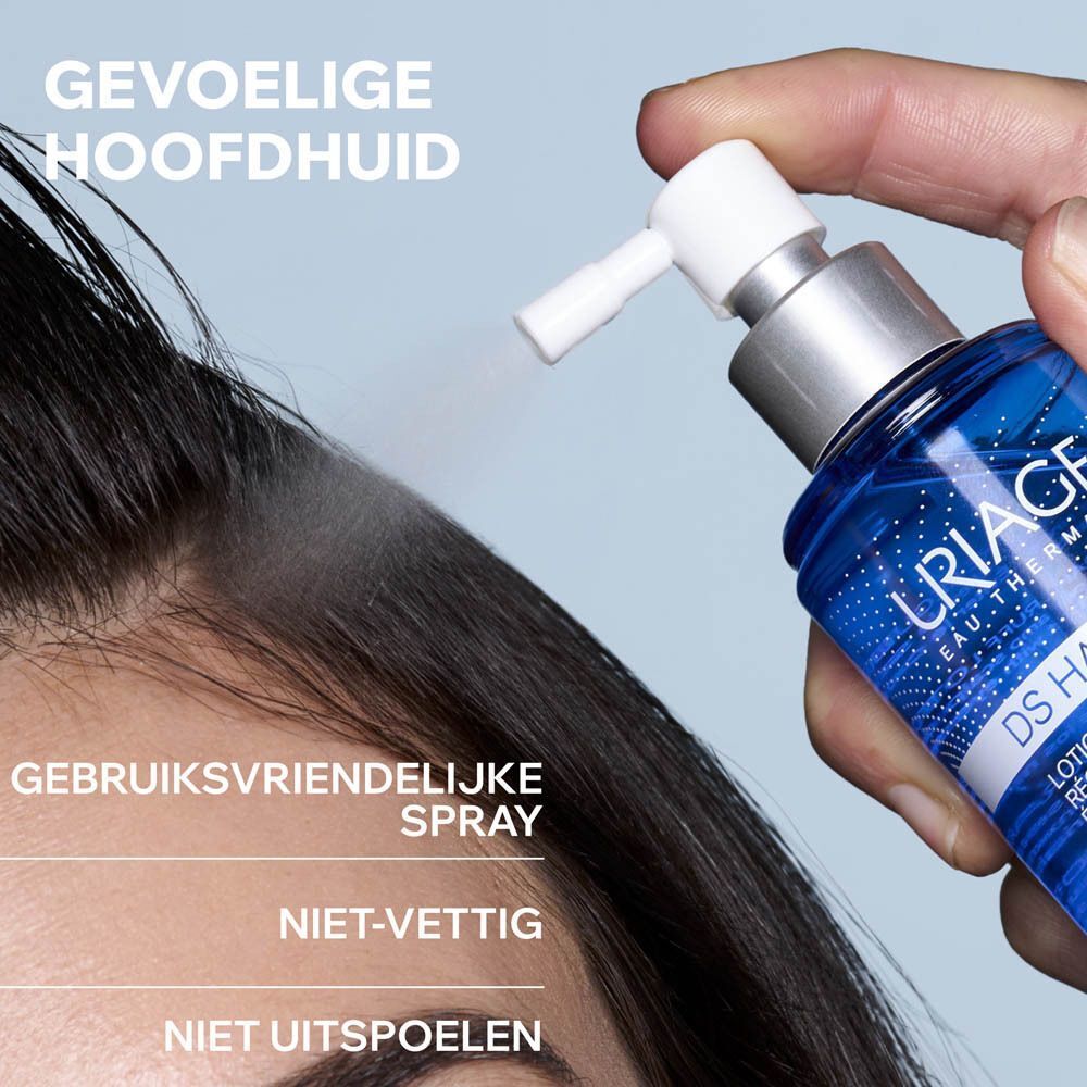 Vrouw die URIAGE DS HAIR Lotion Spray op de hoofdhuid spuit. Tekst: Gebruiksvriendelijke spray, Niet-vettig, Niet uitspoelen.