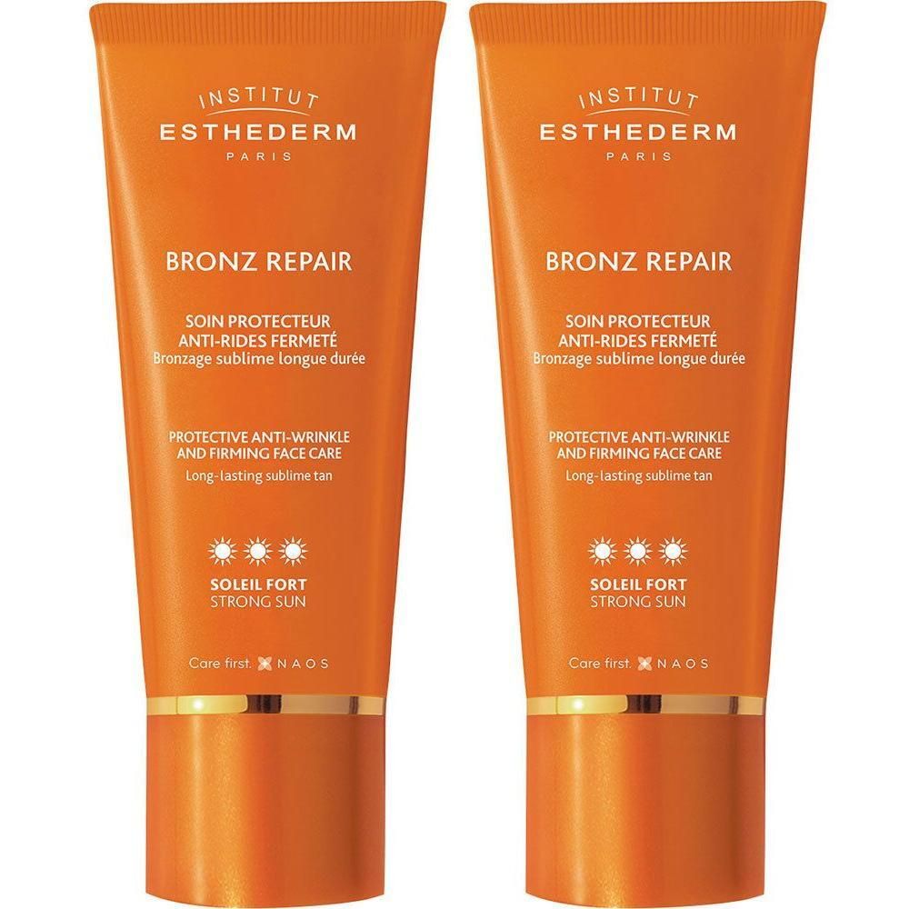 Deux tubes Institut Esthederm Bronz Repair Soleil Fort. Emballage orange avec texte et logo. Fermeture dorée.