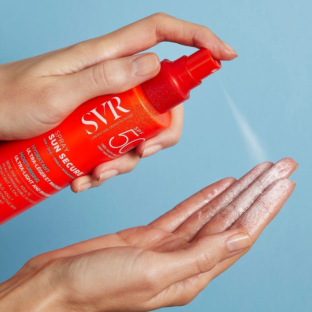 Eén hand spuit een vloeistof uit een oranje fles op de andere hand. Opschrift: SVR, SUN SECURE, SPF 50+.