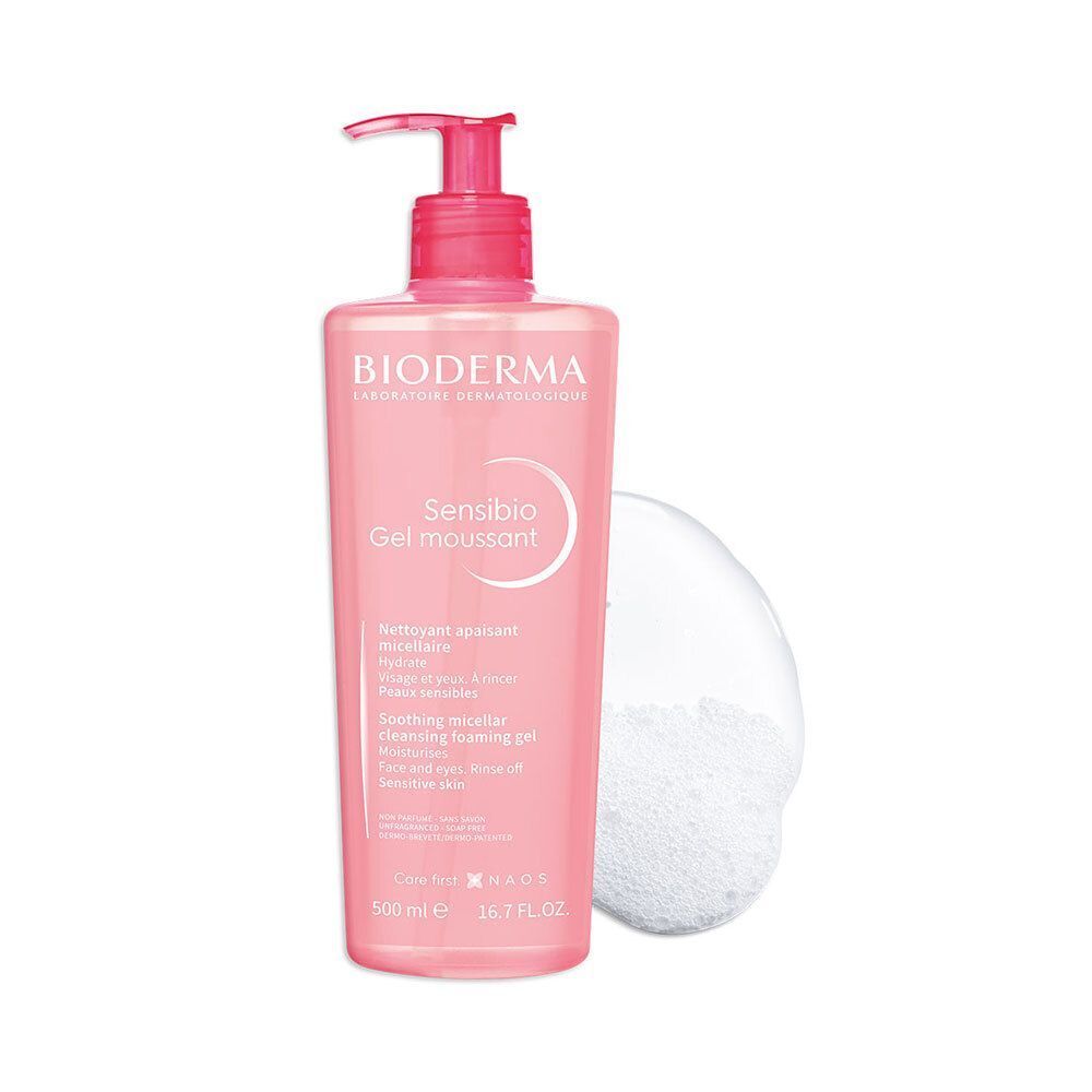 Flacon rose avec pompe doseuse et mousse. Inscription: Bioderma Sensibio Gel moussant. Texte en français et anglais.