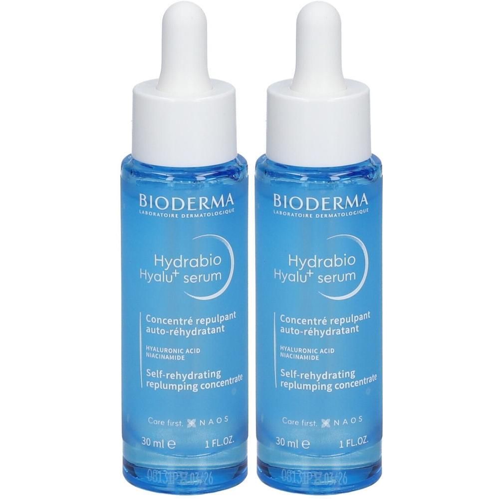 Deux flacons de sérum BIODERMA Hydrabio Hyalu+. Flacons en verre bleu avec bouchons blancs et pipettes. Texte: Hydrabio, Hyalu+ serum, 30 ml.