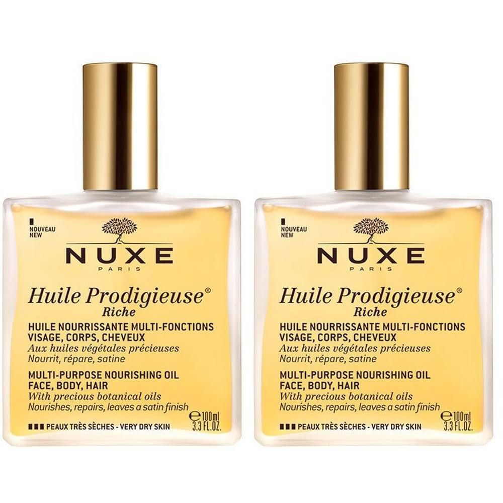 Twee flessen NUXE Huile Prodigieuse® riche. Vierkante glazen flessen met gouden doppen. Etiket met productinformatie.