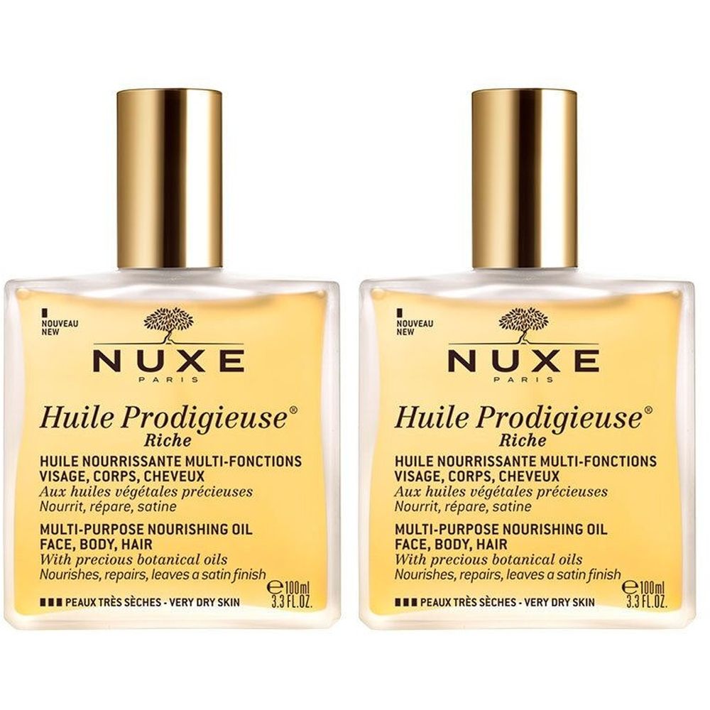 Deux flacons de NUXE Huile Prodigieuse® riche. Flacons carrés en verre avec bouchons dorés. Étiquette avec informations produit.