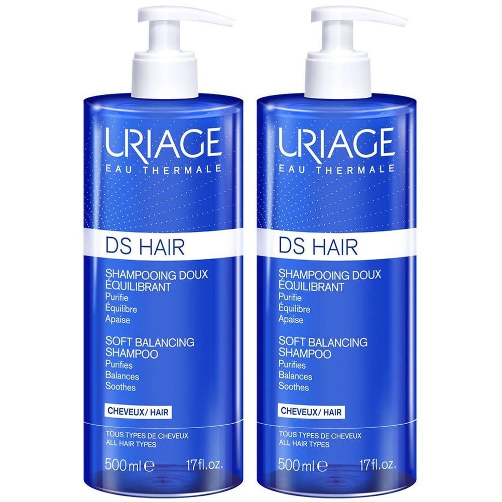 Twee blauwe flessen Uriage DS Hair Shampooing Doux Équilibrant. Witte pompen. Tekst in het Frans en Engels.