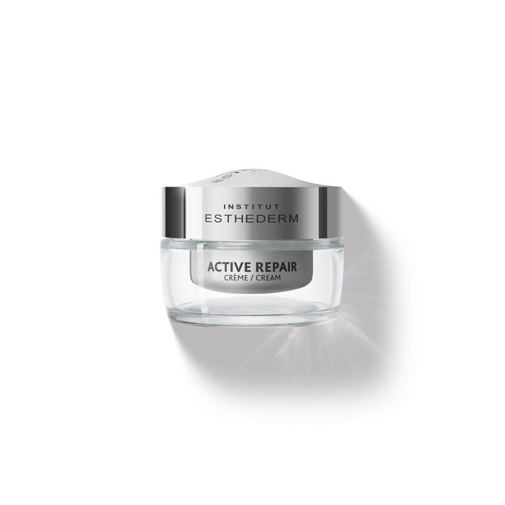 Un pot de crème INSTITUT ESTHEDERM Active Repair. Récipient en verre avec couvercle argenté. Texte: ACTIVE REPAIR, Crème / Cream.