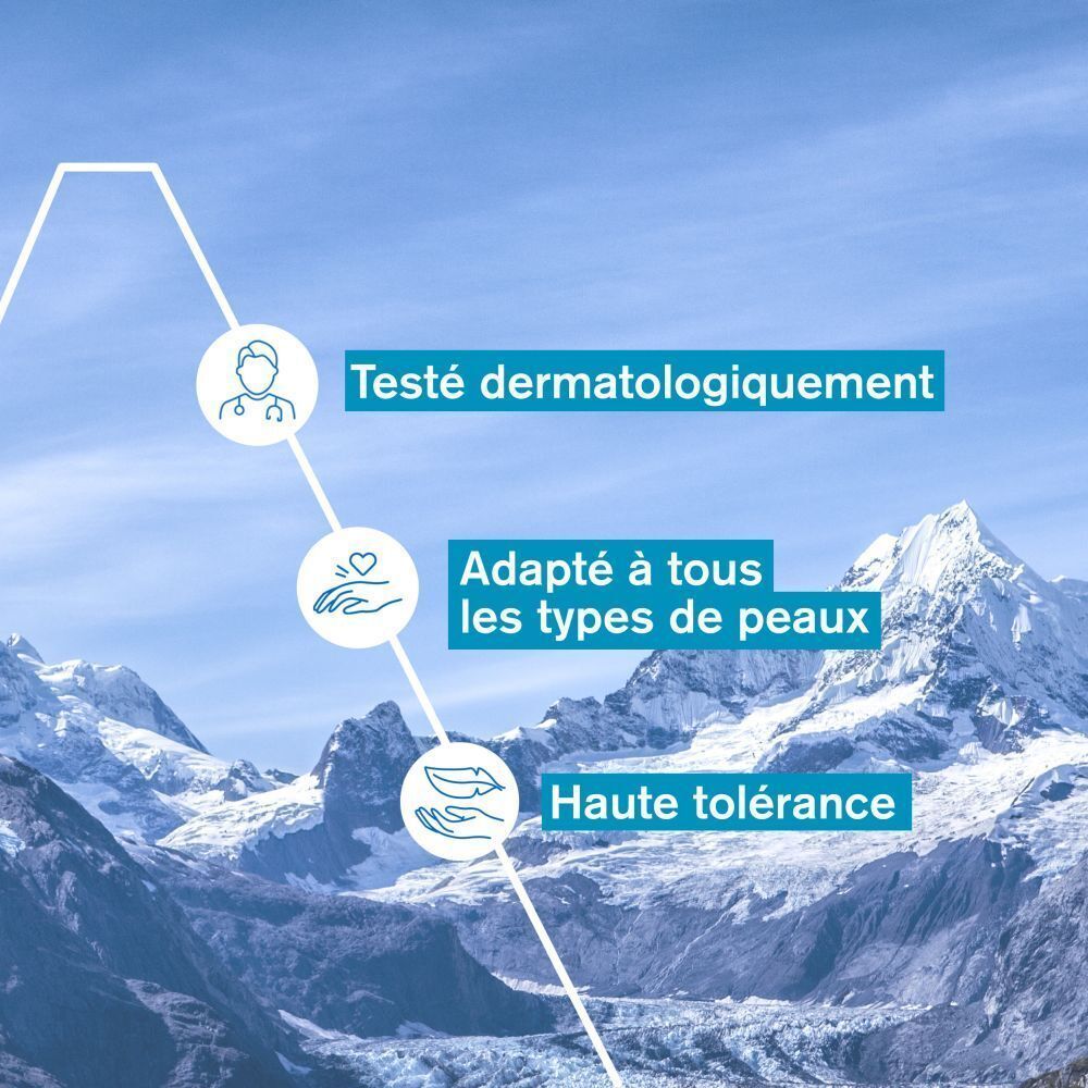 Texte : Testé dermatologiquement, adapté à tous les types de peaux, haute tolérance. Fond : paysage de montagne.
