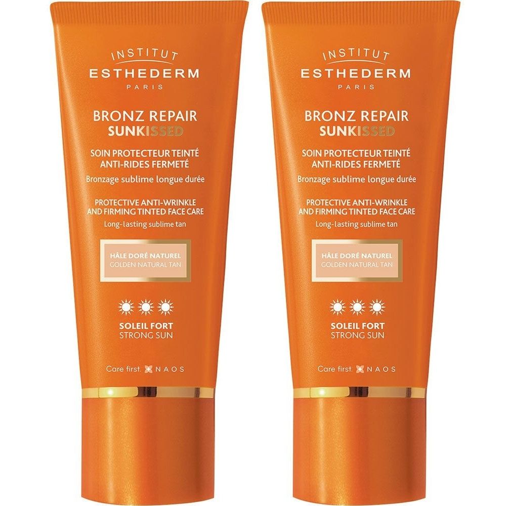 Twee tubes INSTITUT ESTHEDERM Bronz Repair Sun Kissed. Oranje verpakking, gouden dop. Tekst: zonbescherming, anti-rimpel.