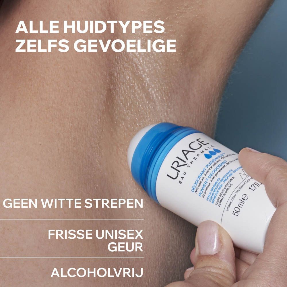 Witte roll-on deodorant met blauwe dop. Opschrift: URIAGE Eau Thermale, Power3 Deodorant, 50ml. Lichte spetter.