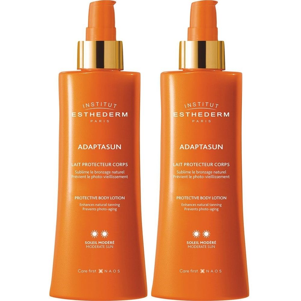 Twee oranje flessen met gouden pompen. Opschrift: Adaptasun, Lait Protecteur Corps, Soleil Modéré.
