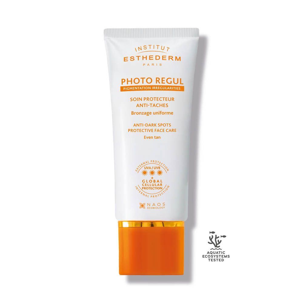 Een tube Institut Esthederm Photo Regul. Witte tube met oranje en gouden elementen. Tekst: Photo Regul, Anti-Taches, NAOS.