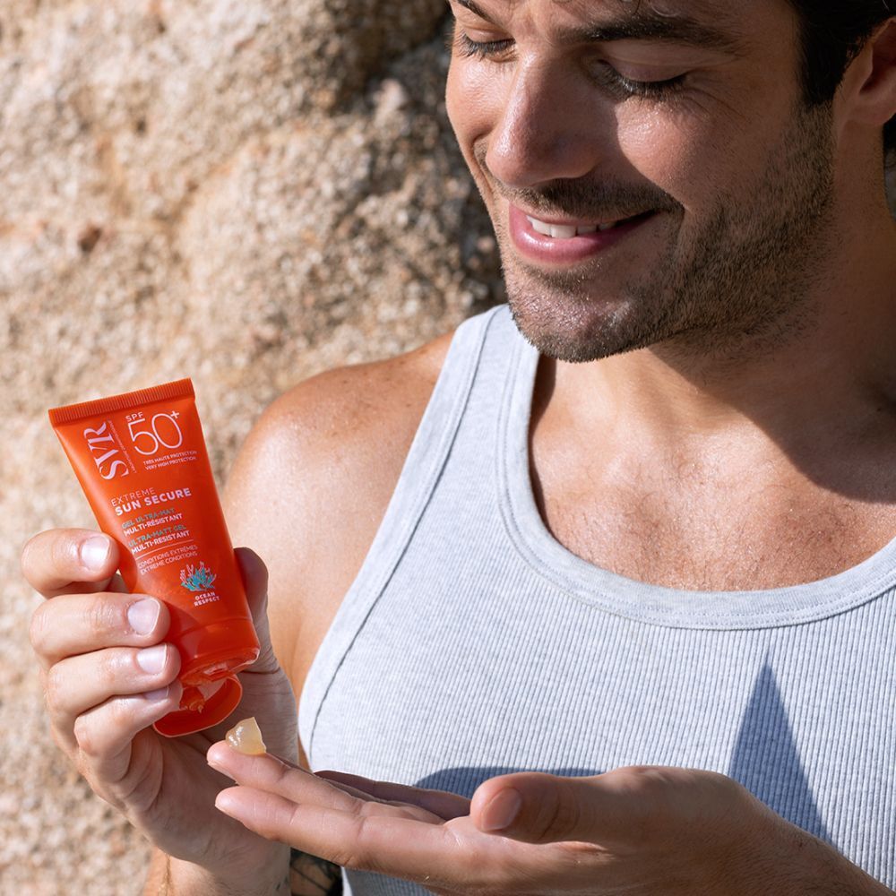 SVR Sun Secure Extreme SPF 50+ tube op zand. Oranje tube met witte tekst. Opschrift: Extreme Sun Secure, Gel Ultra-Mat.