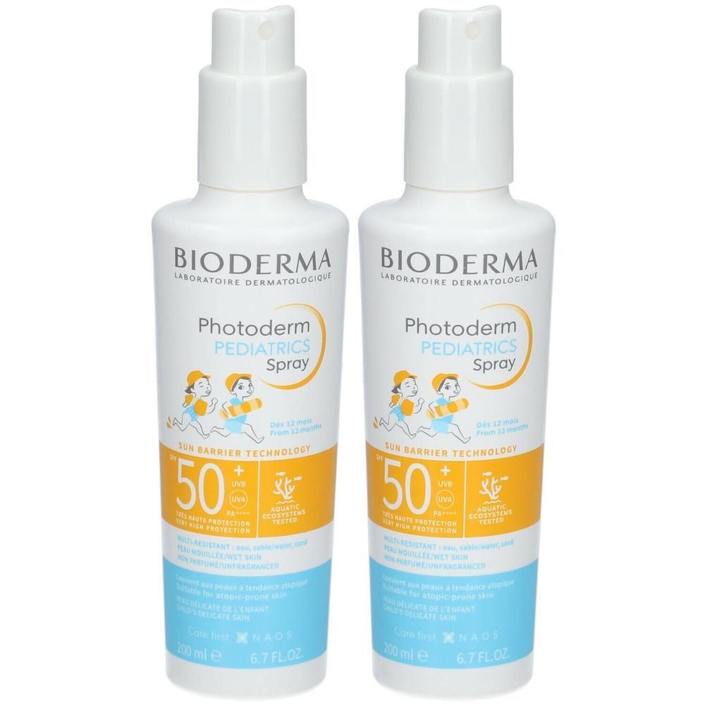 Twee flessen Bioderma Photoderm Pediatrics Spray SPF50+. Witte flessen met spraykop, geel en blauw etiket.