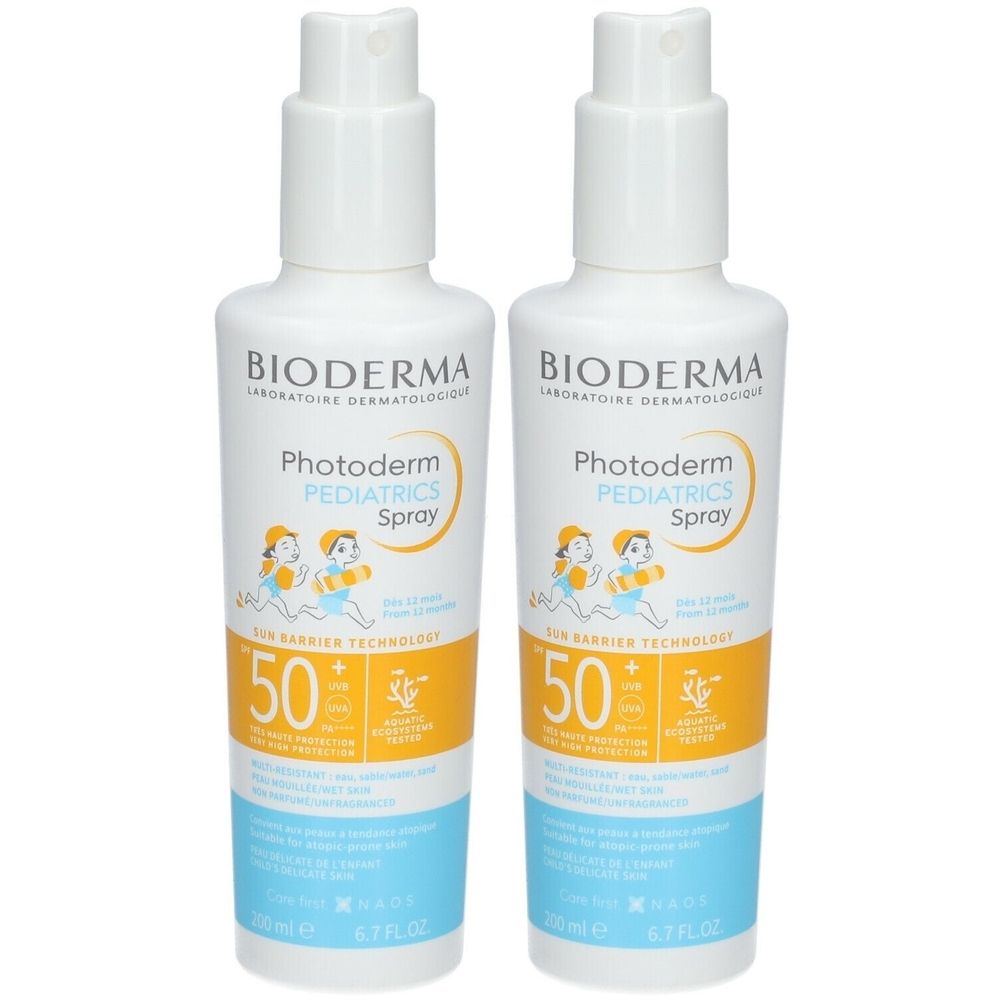 Twee flessen Bioderma Photoderm Pediatrics Spray SPF50+. Witte flessen met spraykop, geel en blauw etiket.