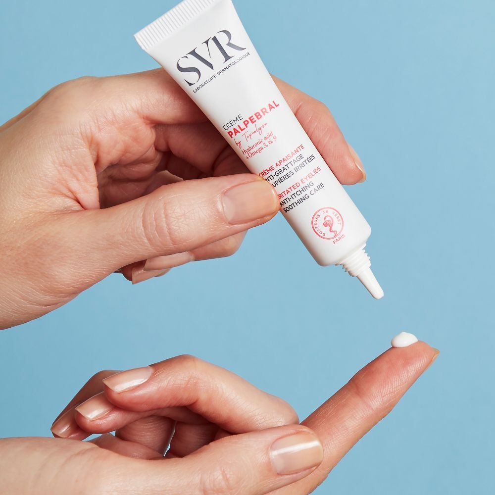 Een tube oogcrème wordt op een vinger aangebracht. Merk SVR, productnaam CREME PALPEBRAL. Tekst: Anti-jeuk, geïrriteerde oogleden.