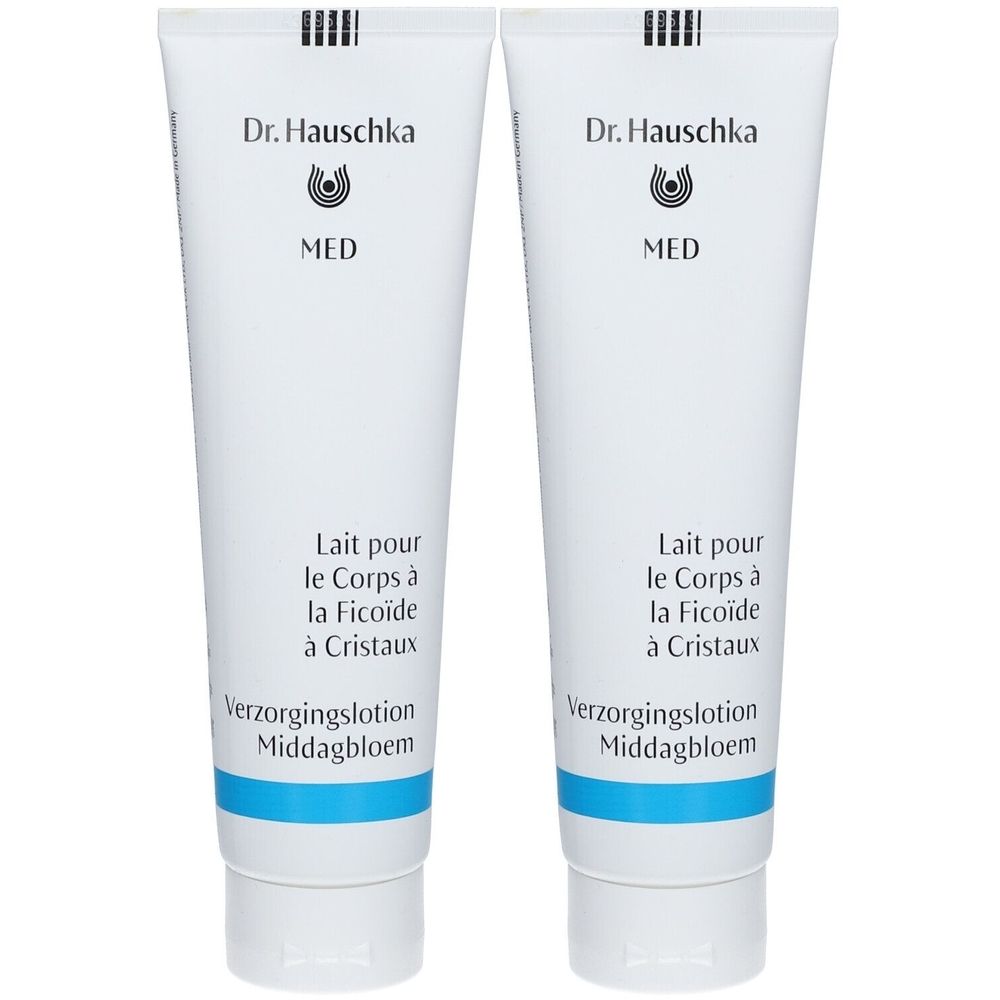 Twee witte tubes met blauwe tekst. Opschrift: Dr. Hauschka MED, Lait pour le Corps à la Ficoïde à Cristaux.