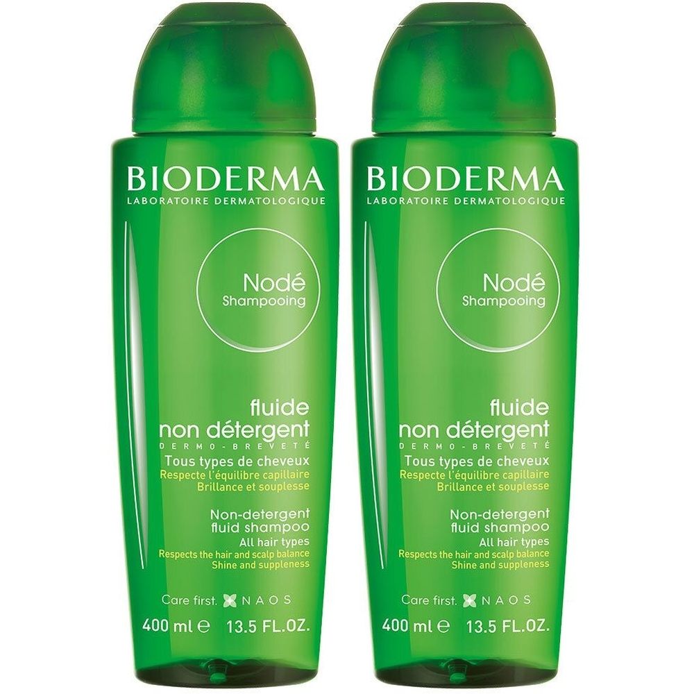 Twee groene flessen Bioderma Nodé Shampooing. Opschrift: Fluide non détergent, 400 ml, 13.5 FL.OZ.