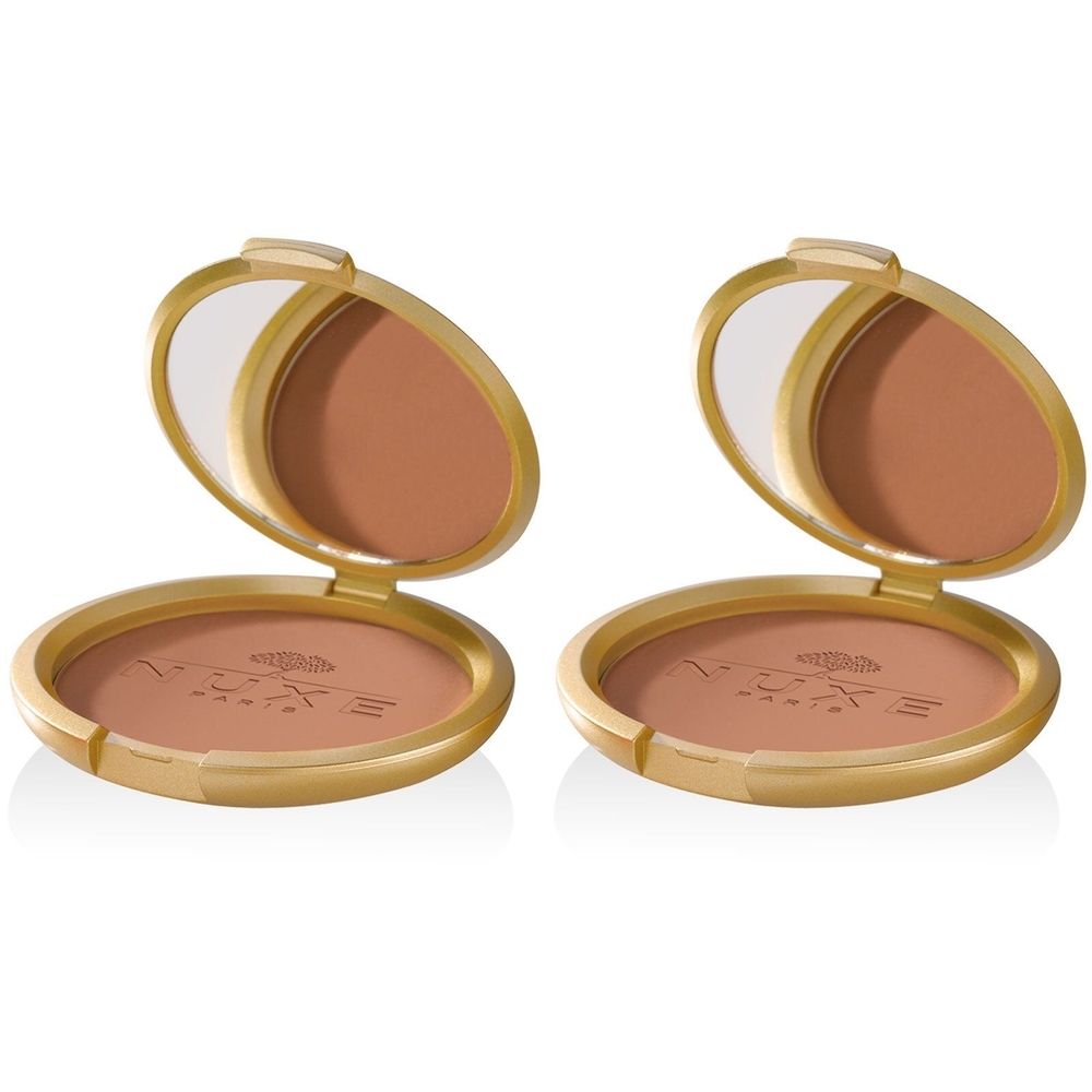 Deux poudriers dorés ouverts, révélant une poudre bronzée et un miroir. Logo NUXE visible sur le boîtier.