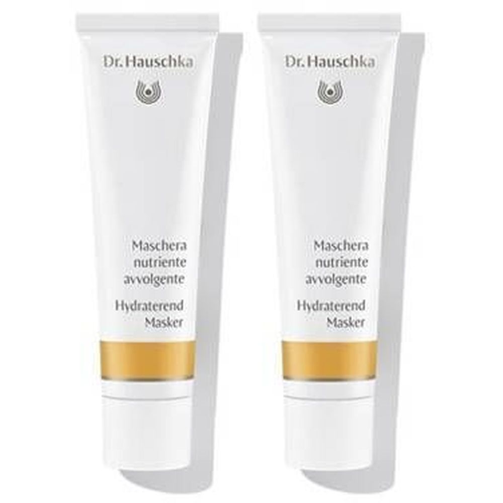 Twee witte tubes naast elkaar. Op elke tube staat "Dr. Hauschka" en productnamen in meerdere talen.