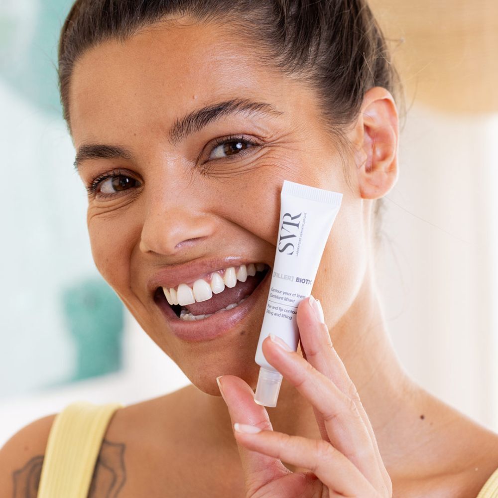 Vrouw houdt een tube SVR [Filler] Biotic vast. Productnaam zichtbaar. Vrouw lacht.