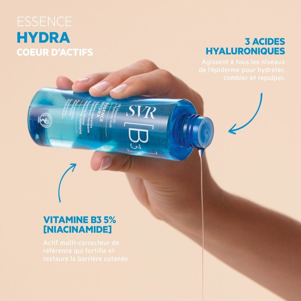 Main versant du liquide d'un flacon bleu. Inscription: SVR [B3] Essence Hydra. Flèches pointant vers les ingrédients.