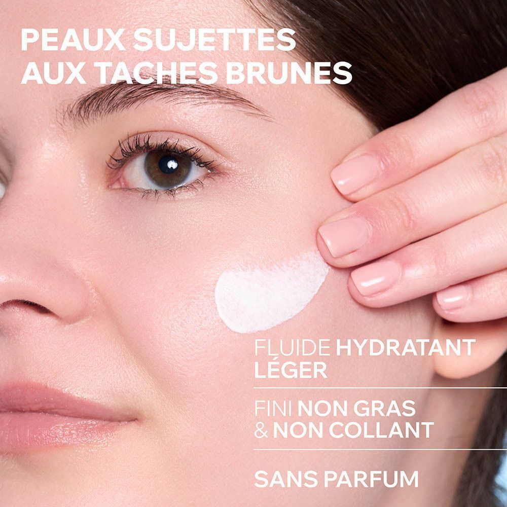 Gros plan sur une peau à laquelle on applique une crème. Texte: Fluide hydratant léger, fini non gras.