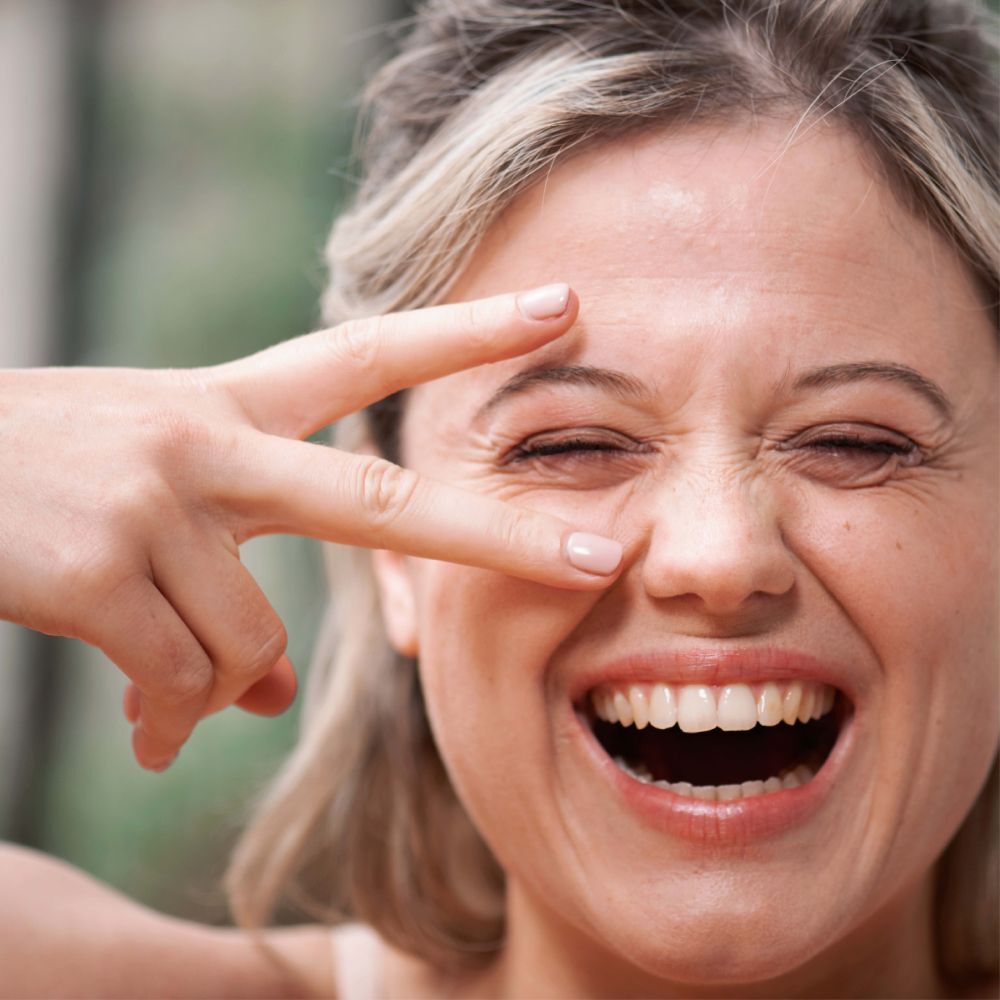Vrouw met gesloten ogen en hand voor het gezicht. Geen producten zichtbaar.