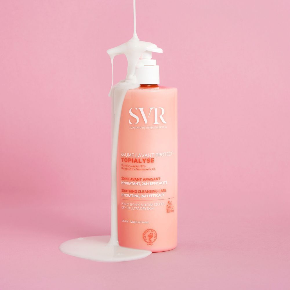 Roze fles met witte pomp. Opschrift SVR, TOPIALYSE, Baume Lavant. Witte vloeistof komt uit de dispenser.
