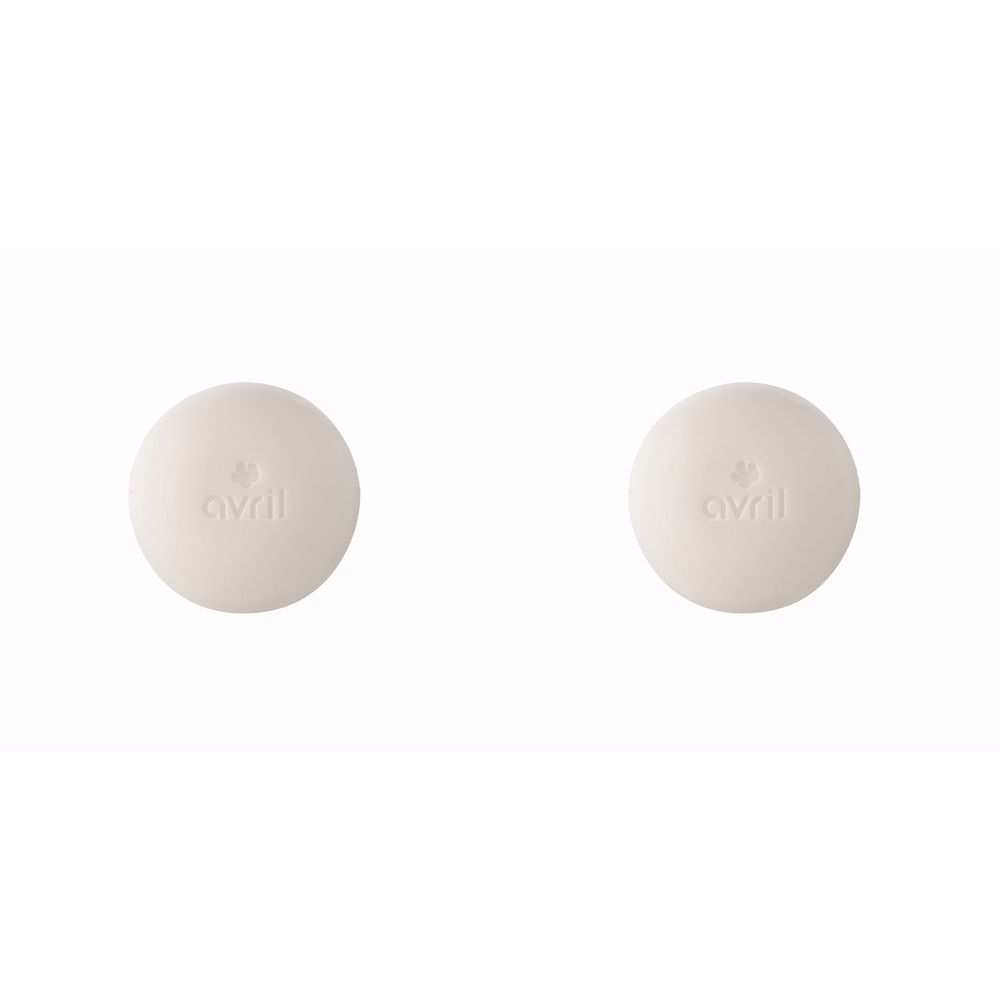 Twee ronde, crèmekleurige zeepjes. Op elk staat het woord "avril" en een symbool.