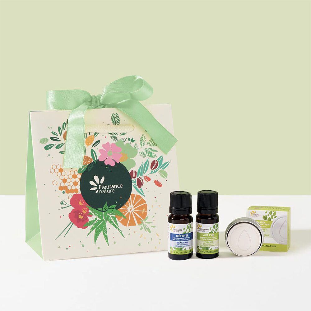 Cadeauset met twee flesjes etherische olie, een kaars en een cadeauzakje met logo.