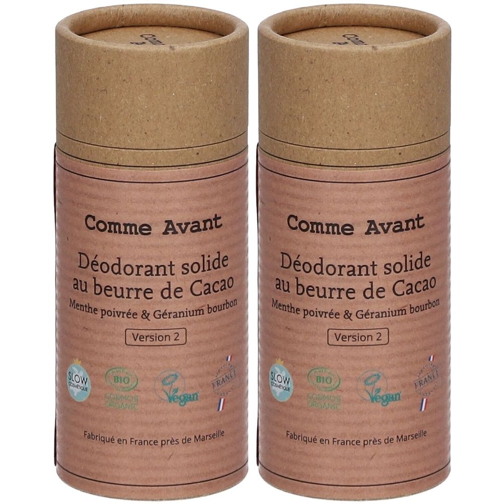 Twee cilindrische deodorants van karton. Opschrift: Comme Avant, Déodorant solide au beurre de Cacao, Version 2. Met bio- en vegan-labels.