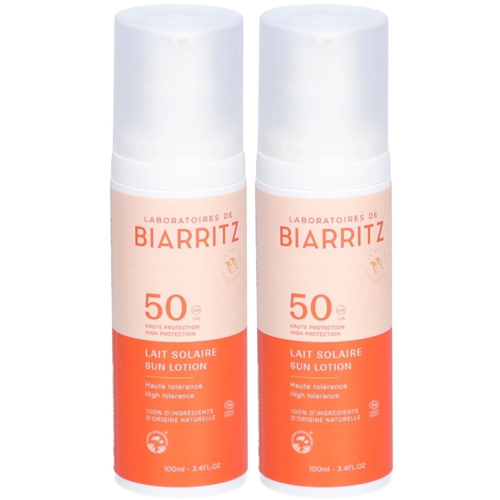Deux flacons de lait solaire. Bouchon blanc, corps orange avec texte. Marque: LABORATOIRES DE BIARRITZ. SPF 50.