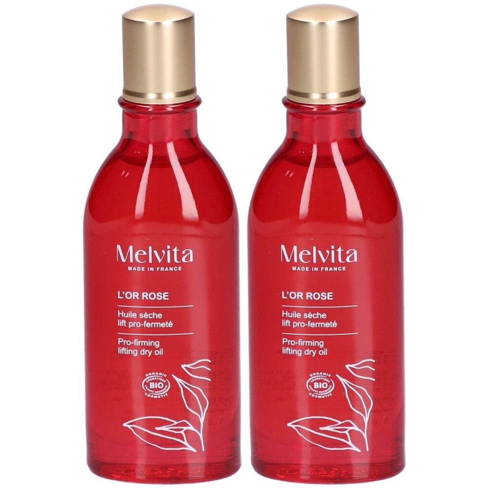 Twee flessen rode vloeistof met gouden dop en etiket. Opschrift: Melvita L'Or Rose, Huile sèche lift pro-fermeté, BIO.