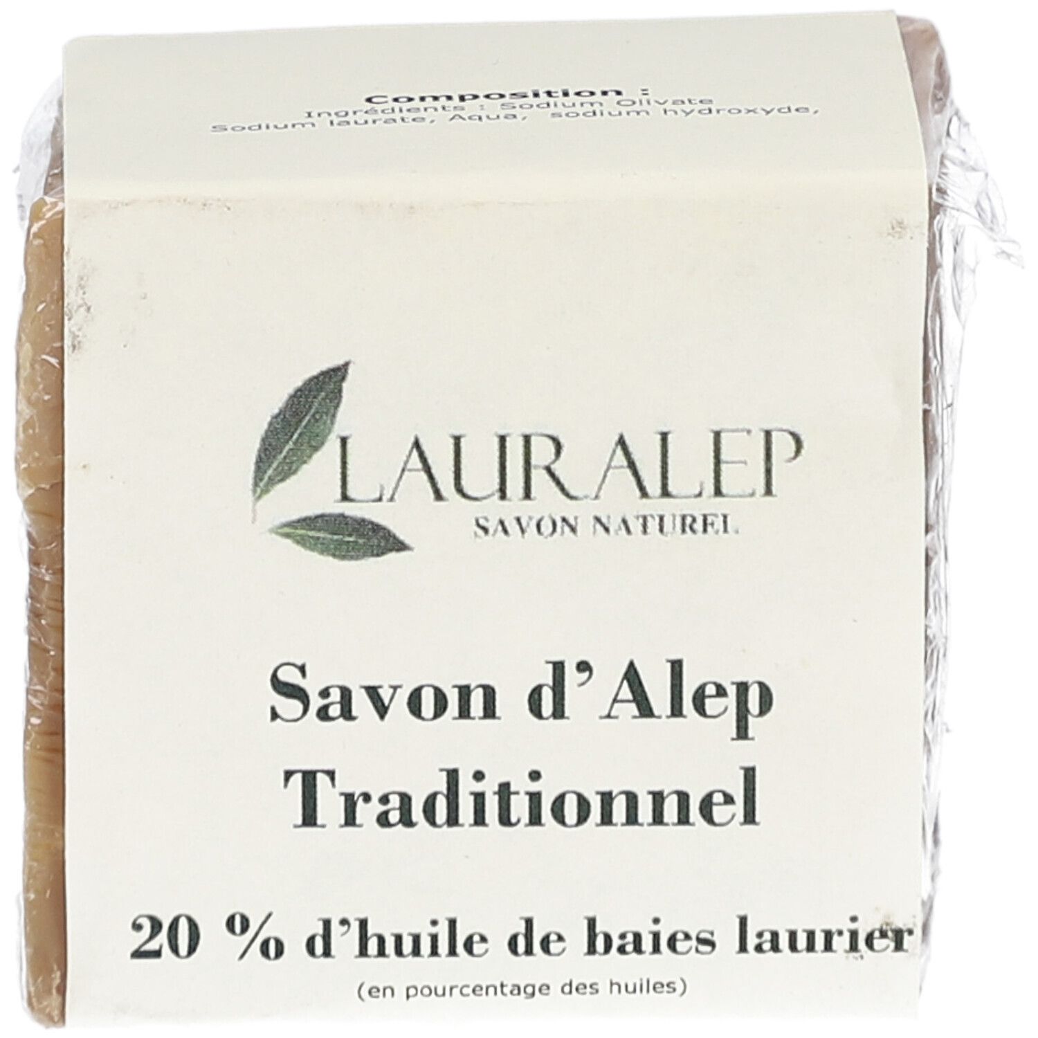 Vierkant blok zeep, verpakt in papier en plastic folie. Opschrift: LAURALEP, Savon d'Alep Traditionnel, 20% huile de baies laurier.