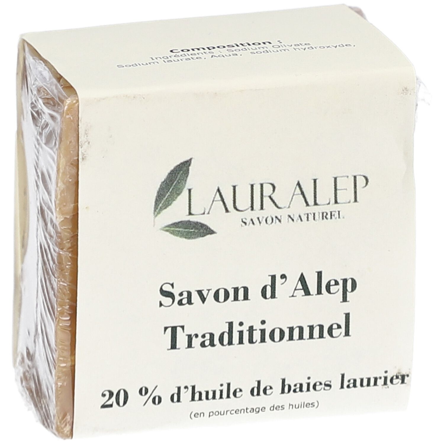 Vierkant blok zeep, verpakt in papier en plastic folie. Opschrift: LAURALEP, Savon d'Alep Traditionnel, 20% huile de baies laurier.