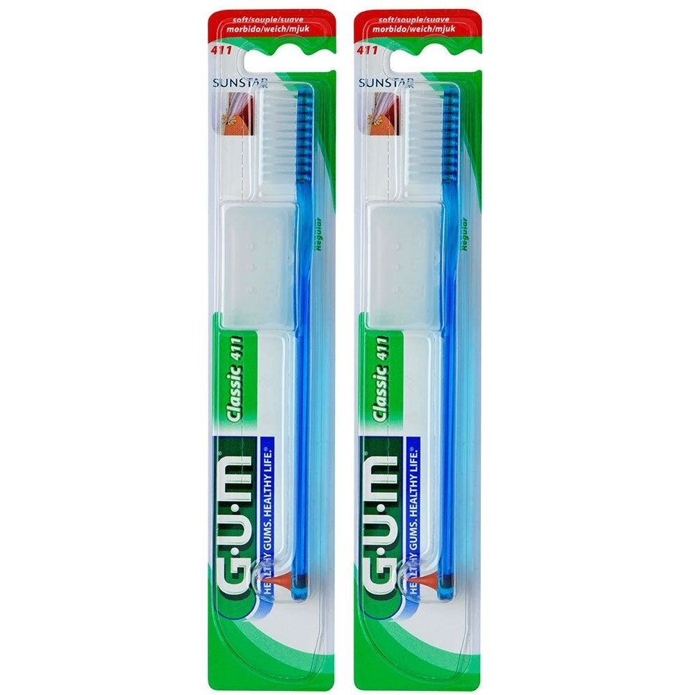 Deux brosses à dents G.U.M Classic 411, emballées. Manches bleus, soies blanches.