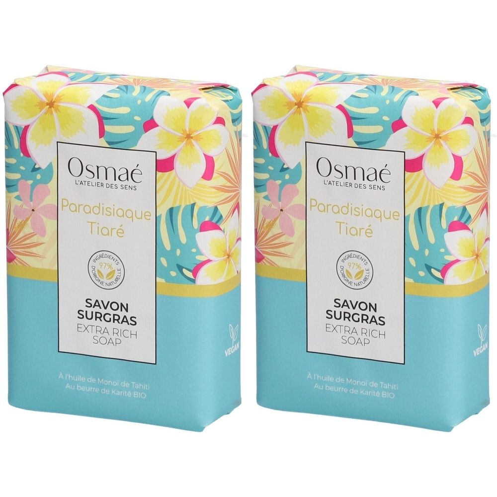 Twee zeepblokken met bloemenmotief. Opschrift: OSMAE, Paradisiaque Tiaré, Savon surgras, Extra Rich Soap. Turquoise en gele verpakking.